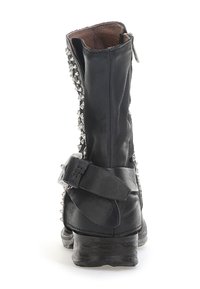 Černé kožené kotníkové boty s stříbrnými cvočky po straně, širokým řemínkem s přezkou a nízkým stohovaným podpatkem. Zobrazeno z zadní strany.