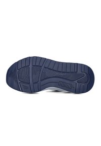 Puma sportschoen zool, met een gestructureerd, marineblauw rubberontwerp met groeven en een op de zijkant geperst logo voor grip en tractie.