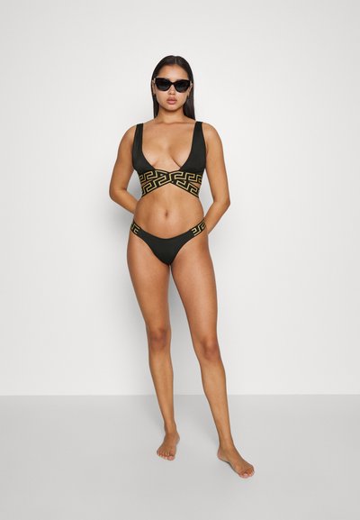 Ensemble de bikini noir avec un motif géométrique doré. Le haut présente un décolleté en V profond et des bretelles larges, tandis que le bas a un design minimaliste et des accents assortis.