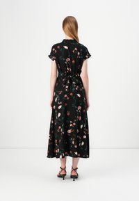 Robe noire à fleurs avec des manches courtes, taille cintrée et jupe fluide. Présente des motifs floraux colorés et un détail noué à l'arrière.