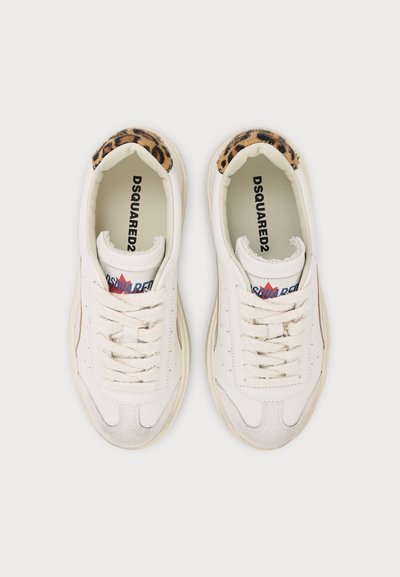 Baskets blanches DSQUARED2 avec lacets écru et détail imprimé léopard sur la partie intérieure du talon, vues de dessus sur fond uni.