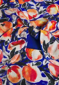 Blommigt tyg med orange persikor och gröna blad på en blå bakgrund, med en knuten detalj i mitten. Mjuk textur, lätt material.