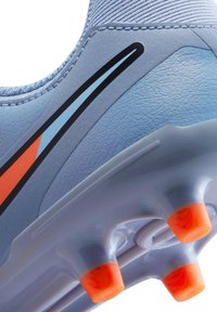 Hellblauer Fußballschuh mit strukturierter Oberfläche, versehen mit schwarzen und orangenen Akzenten. Enthält orangene Gummistollen an der Sohle.