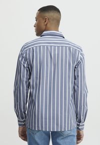 Gestreepte blouse met lange mouwen in blauw en wit. Heeft een klassieke kraag, knopenmanchetten en een rechte zoom. Gemaakt van katoen met een zachte structuur.