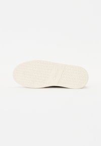 Semelle de chaussure avec motif texturé circulaire et nom de la marque "Gabor" embossé au centre, affiché sur fond blanc.