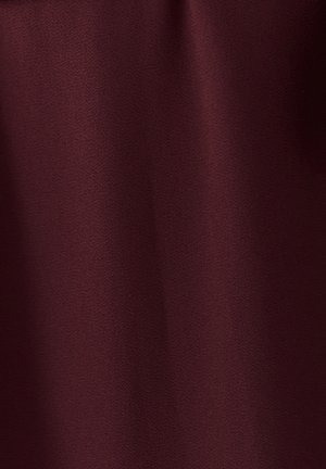 Bordová látka s hladkou textúrou a jemným vzorom, mäkko padajúca, ukazujúca svetelné pohyby a bohatú, hlbokú farbu.