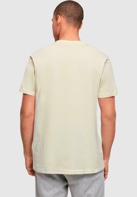 Kortærmet t-shirt med rund hals i lysebeige bomuld. Glat tekstur med en afslappet pasform og lige kant. Enkel bagside, ingen grafik.