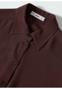 Burgundowa koszula z guzikiem i usztywnionym kołnierzykiem. Wykonana z miękkiego materiału, z gładką fakturą i pięcioma dopasowanymi guzikami z przodu.