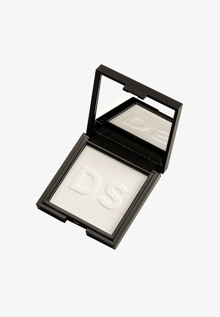 Petit étui noir compact pour maquillage avec une poudre blanche pressée embossée des lettres "DS" et un miroir à l'intérieur du couvercle.