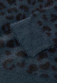 Tkanina z futra syntetycznego w ciemnoniebieskim kolorze z czarnym wzorem w panterkę. Miękka, teksturowana powierzchnia o puszystym dotyku, zróżnicowana wysokość włosia i wzory.