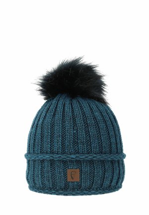 Teal knitted beanie with ribbed texture, foldable cuff, and black faux fur pom-pom on top. Features a small brown leather logo patch.
