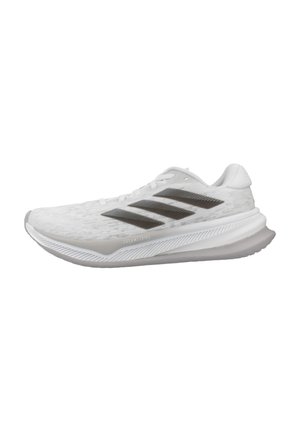 Weißer Sportschuh mit strukturiertem Obermaterial, drei dunklen Streifen und einer hellgrauen Sohle. Bietet ein stromlinienförmiges Design und eine abgerundete Ferse.