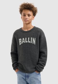 Grijze gebreide trui met "BALLIN" in witte tekst over de borst, met een ronde hals en lange, iets losse mouwen.