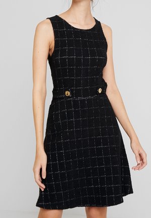 Ärmelloses schwarzes Kleid mit strukturierter Oberfläche und feinem Karomuster, tailliert mit zwei goldenen Knöpfen und einem ausgestellten Rock.