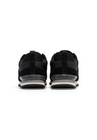 Scarpe da atleta nere con tomaia in tessuto testurizzato, suole imballate e un intersuola grigia a contrasto, progettate per comfort e supporto.