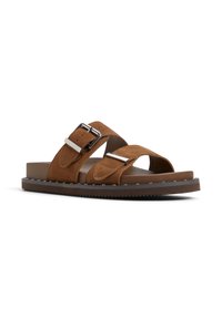 Sandales en daim marron avec deux larges sangles et boucles en argent, semelle intérieure rembourrée et semelle en caoutchouc avec des accents cloutés.