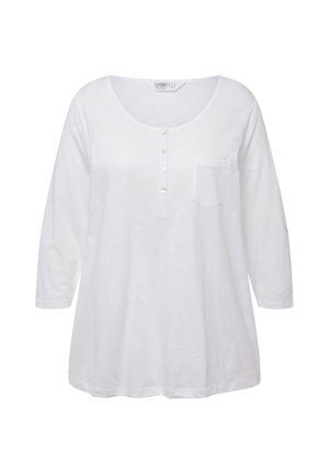 Top bianco a maniche lunghe con scollo a pomodoro, fronte con otto bottoni, piccola tasca sul petto e vestibilità morbida. Realizzato in tessuto leggero.