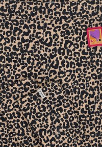 Luipaardprint stof in beige en zwart met een LOOKS-label en een kleurrijke "LOVE CLUB" badge. Lichtgewicht, zachte textuur.