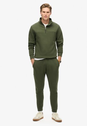 Olivgrüner Sweatshirt mit durchgehendem Reißverschluss und hohem Kragen, kombiniert mit passenden, schmal zulaufenden Jogginghosen. Verfügt über ein schlichtes Design und gerippte Bündchen.