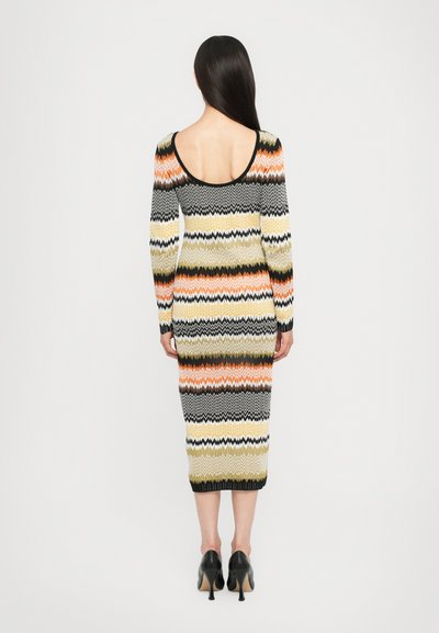 Abito lavorato a maglia con silhouette aderente, motivo zigzag multicolore in arancione, giallo, nero e bianco, con schiena bassa e maniche lunghe.