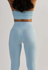 Jasnoniebieski, sportowy crop top i pasujące legginsy z wysokim stanem, wykonane z elastycznego materiału o rypsowej fakturze i zaokrąglonych szwach.