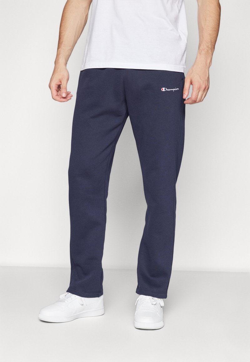 Navy blue sweatpants made of soft cotton with a relaxed fit. Features a small embroidered logo on the side and elastic cuffs at the ankles.