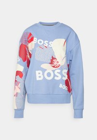 Sudadera azul con patrones florales en rojo y blanco, que presenta la palabra "BOSS" en blanco y en negrita. Mangas largas y puños acanalados, textura suave.
