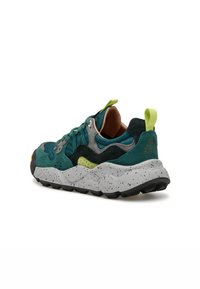 Sneaker teal e nera realizzata in suede e mesh, con una suola maculata bianca e grigia, dettaglio giallo e linguetta verde sul tallone.