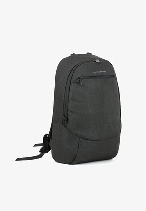 Czarny plecak z tkaniny o gładkiej fakturze, zaokrąglonym kształcie, z przednią kieszenią na zamek błyskawiczny i regulowanymi, wyściełanymi paskami. Minimalistyczny design.