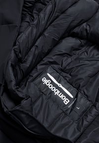 Sort isoleret jakke indvendigt med quiltet for, der har et stofmærkat med "bamboozle" og størrelse "L", med en glat tekstur.