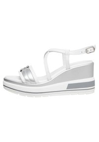 White wedge sandals with silver accents, featuring thin straps and a textured, rounded platform. Adjustable ankle buckle detail included.