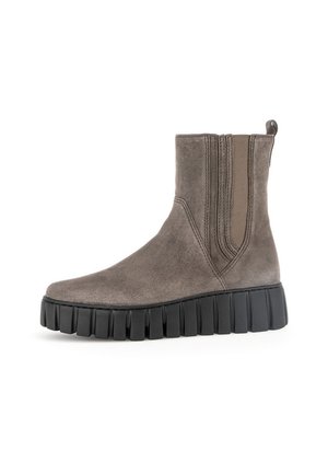 Grijze suède enkelboot met elastische zijpanelen, ronde neus en een dikke zwarte rubberen zool met opvallende groeven.
