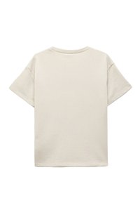 Beige bomulds T-shirt med korte ærmer, rund halsudskæring og en afslappet pasform. Glat tekstur uden synlige mønstre eller detaljer.