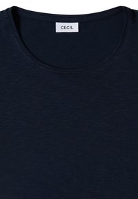 T-shirt bleu marine foncé à col rond avec une étiquette blanche affichant le nom de la marque "CECIL" cousue à l'intérieur du col.