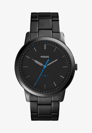 Montre analogique noire avec un bracelet en métal noir mat, cadran noir minimaliste, index des heures argentés et aiguilles des secondes bleues. Présente un boîtier rond.