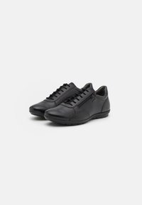 Sneakers in pelle nera con punta arrotondata, design con lacci e cerniera laterale. La suola in gomma presenta una leggera texture per una migliore aderenza. Stile minimalista.