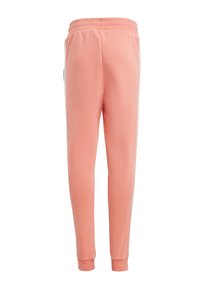 Joggers de color melocotón, hechos de suave algodón con un corte relajado, cinturilla elástica y puños en los tobillos. Sin bolsillos visibles.