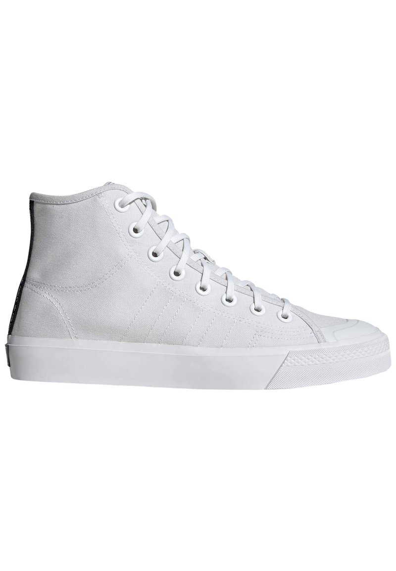 High-top sneakers in white canvas material with a textured finish, featuring white laces, rubber sole, and a contrasting black back panel.