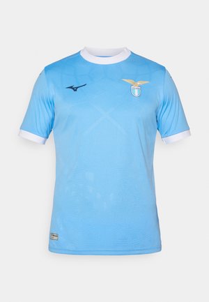 Sky blue short-sleeve jersey with a round white collar, featuring a gold emblem, textured pattern, and black logo on the left chest.