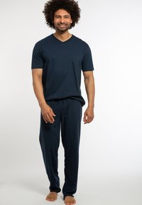 Marineblaues Kurzarm-V-Ausschnitt-Oberteil mit einer Tasche, kombiniert mit passenden Jogginghosen mit Kordelzug, beide aus weichem, leichtem Stoff.