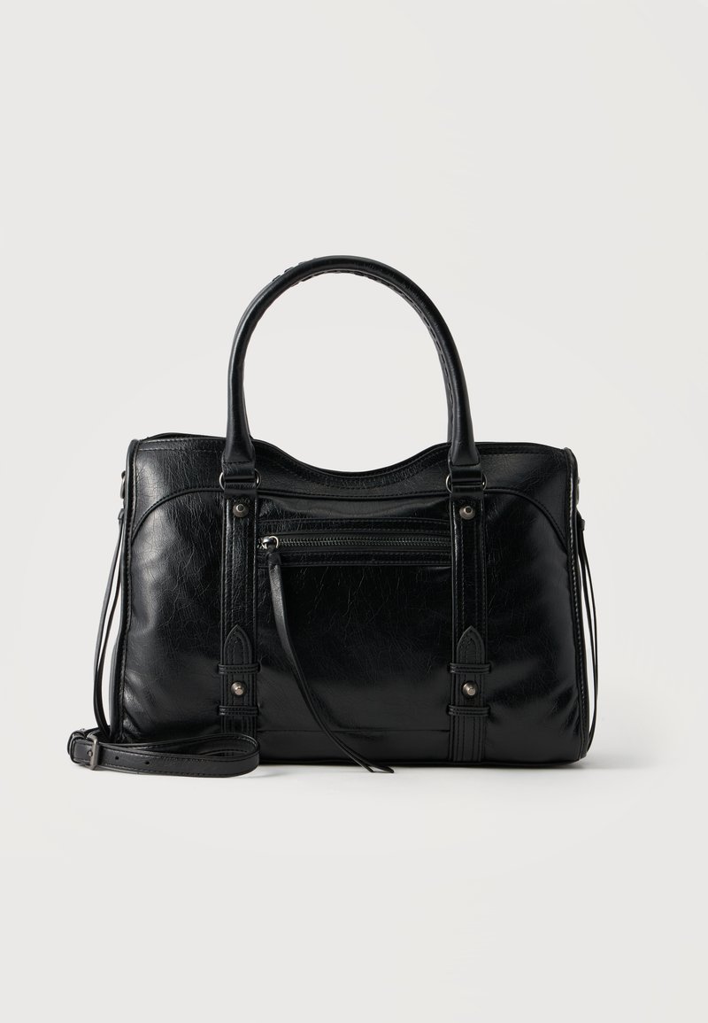 Sac à main en cuir noir avec double poignée, poche avant zippée, sangles décoratives et bandoulière amovible sur fond clair.