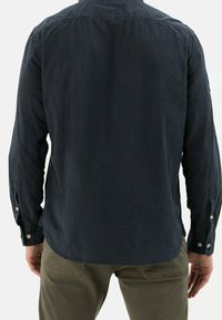 Dunkelblaues Langarmshirt mit glatter Textur, einfachen Knopfdetails und abgerundetem Saum. Keine sichtbaren Muster. Rückansicht.