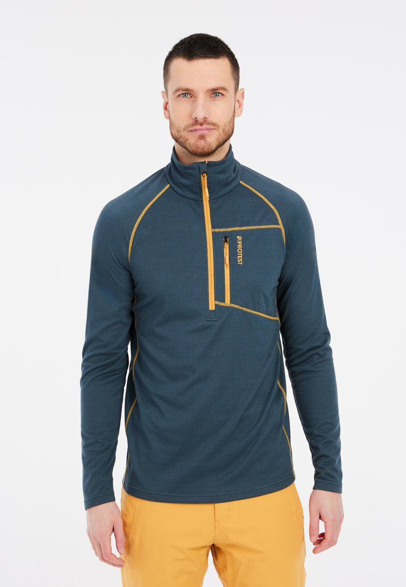 Donkerblauwe pullover met een half-rits kraag, voorzien van oranje accenten en een ritssluitingzak op de borst. Gemaakt van een gestructureerde stof.