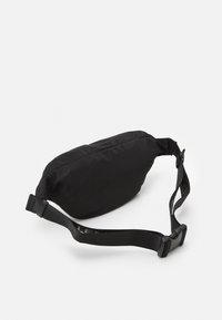 Svart midjeväska i nylon med en elegant design, som har en böjd form, justerbar rem och spänne i slitstark plast.