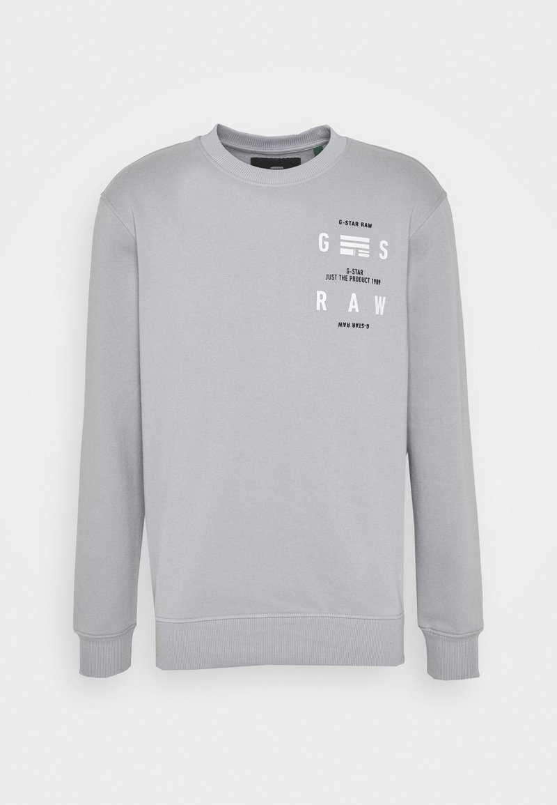 Sudadera gris claro con cuello y puños acanalados, con texto impreso en blanco y diseños gráficos en la parte frontal. Textura de tela suave.