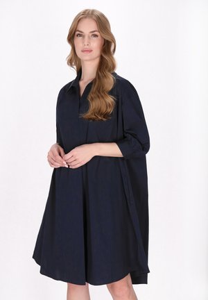 Marineblaue, knieumspielende Kleid mit Kragen und dreiviertel Ärmeln; zeichnet sich durch einen lockeren Schnitt und eine glatte Stofftextur aus.