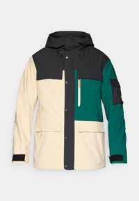 Casaco em bloco de cor com capuz preto, corpo em creme e detalhes em verde-água. Apresenta fecho de pressão, múltiplos bolsos e punhos ajustáveis.