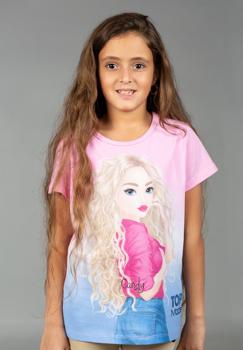 T-shirt in cotone rosa chiaro con illustrazione stampata di una ragazza con lunghi capelli biondi e occhi azzurri, che indossa un top rosa e pantaloncini in denim.