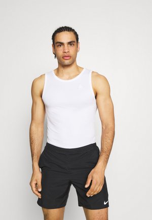 Weißes ärmelloses Tanktop aus leichtem Stoff mit einem runden Ausschnitt und einem kleinen grauen Logo auf der Brust, kombiniert mit schwarzen Shorts.