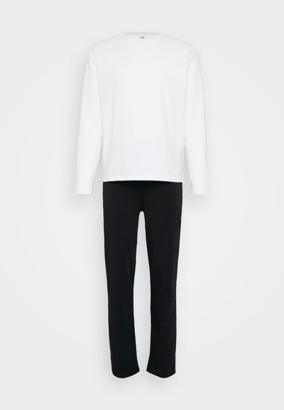 Valge pika varrukaga särk ja mustad püksid. Särgil on ümmargune kaelus; püksid on sirge lõikega. Mõlemad on valmistatud pehmest ja siledast kangast.